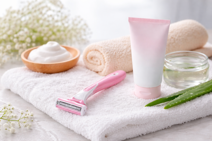 Sanfter Rasierer mit Pflegeprodukten auf einem Handtuch als Symbol für schonende Intimrasur