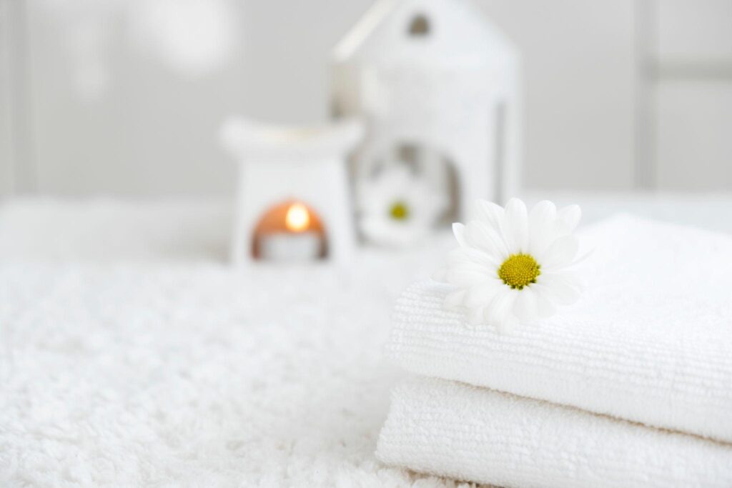 Weiches Handtuch mit Gänseblümchen als Symbol für natürliche Intimpflege und sanfte Regeneration nach der Geburt